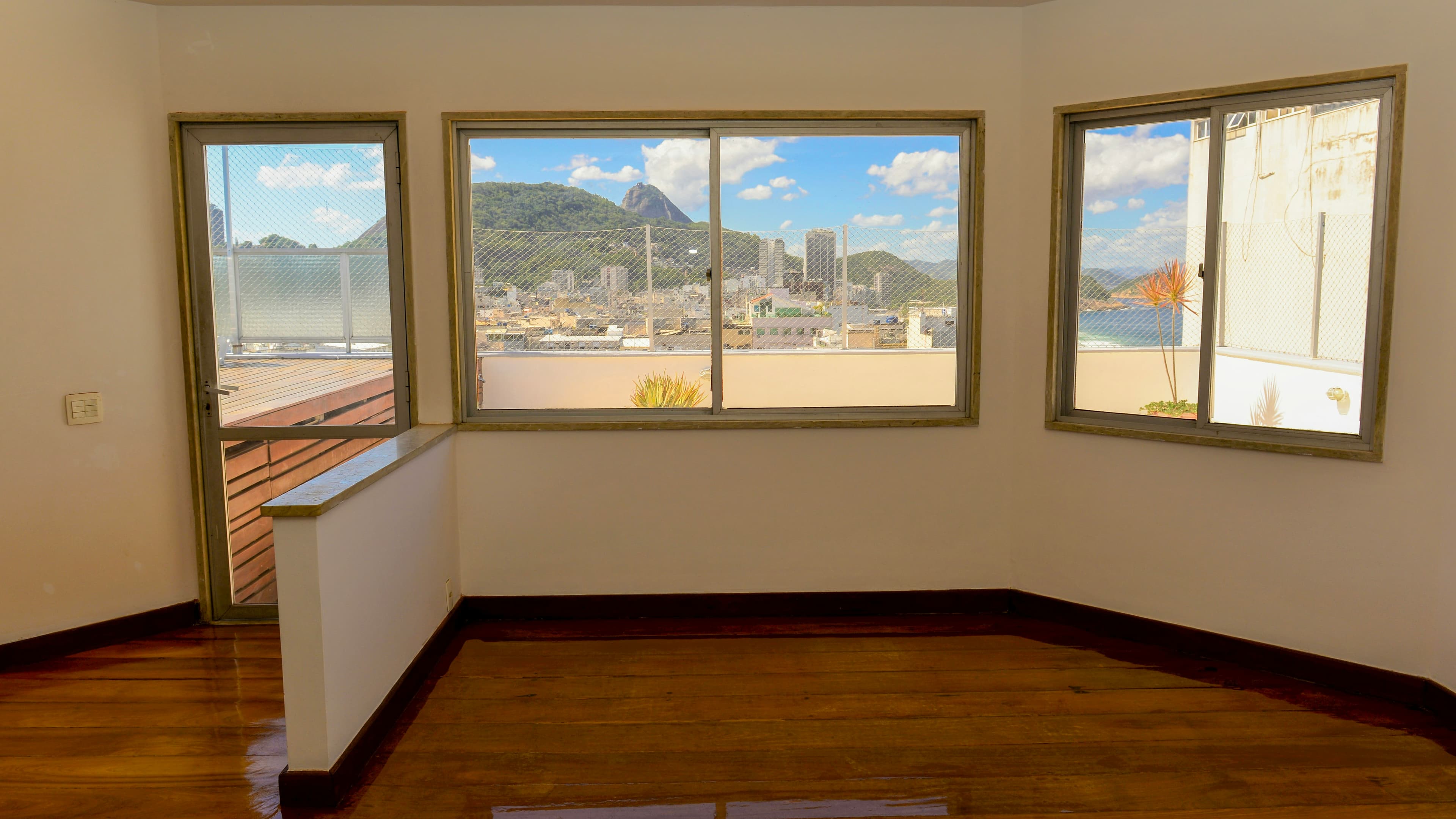 Vista da cidade e do mar através da janela de um apartamento